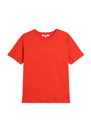 Camiseta de algodón roja con mangas cortas, con un cuello circular y el texto en relieve 'ATTITUDE' en el pecho. Textura suave.