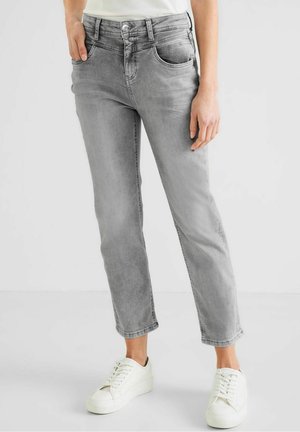 Jeans in denim grigio con vestibilità rilassata, design a cinque tasche e leggera scoloritura, abbinati a sneakers bianche. Tessuto morbido e forma a gamba dritta.