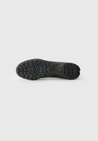 Semelle de chaussure de sport noire en caoutchouc texturé pour une traction optimale, dotée d'un design épuré et d'un accent vert subtil au centre.