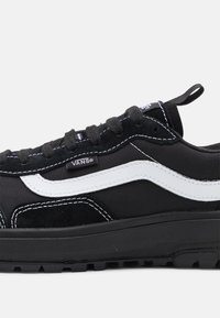 Černé plátěné a semišové tenisky s bílým bočním pruhem, černými tkaničkami a texturovanou gumovou podrážkou. Obsahují logo na boku.