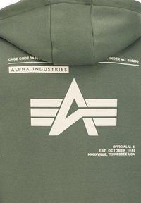 Felpa verde in cotone con un grande logo grafico bianco, contenente una "A" stilizzata e strisce sul retro, accompagnato da testo di branding sopra.