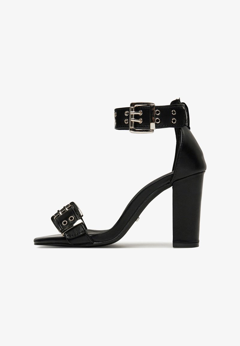 Sandalo nero con tacco alto, con due cinturini regolabili con fibbia, tacco spesso a blocco e punta aperta su sfondo bianco.