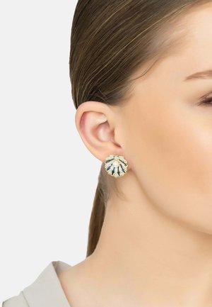 Pendientes en tono dorado con forma de concha, que cuentan con un centro de perla blanca, acentos de esmalte azul y detalles de piedras preciosas claras.