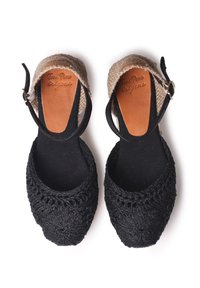 Černé háčkované espadrilky s hnědými koženými stélkami a tkanou jutovou patou. Nastavitelný černý kotníkový pásek s kovovou sponou jako akcent.