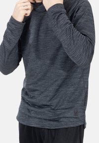 Langarm-Sportshirt aus strukturiertem, dunkelgrauem Stoff mit subtilen horizontalen Streifen und einem Logo auf der unteren linken Seite.