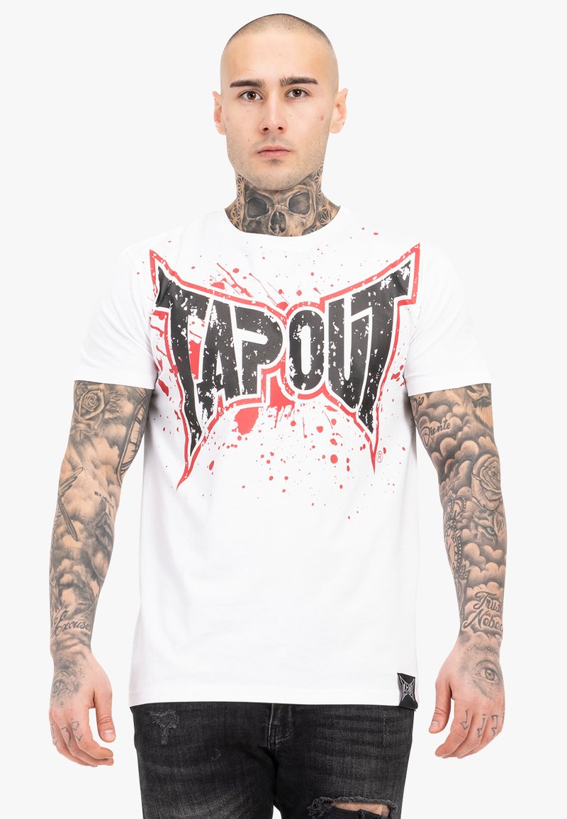 Camiseta de algodón blanca con un atractivo gráfico en negro y rojo que dice "TAPOUT" con diseño salpicado. Tiene mangas cortas y cuello redondo.