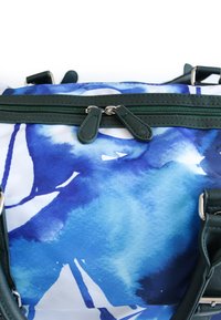 Blaue und weiße, abstrakte, aquarellierte Tasche mit dunkelgrünen Lederakzenten, ausgestattet mit einem Doppelreißverschluss und verstellbaren Trägern.