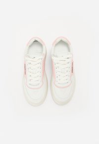 Hvite joggesko med rosa detaljer, snøring, perforert tå og flat gummisåle. Har branding på siden. Laget av mykt lær.
