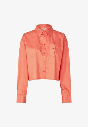 Rövidített ing élénk korallszínben, vékony fehér függőleges csíkokkal. Hegyes gallérral, elöl gombos záródással és mellzsebbel.