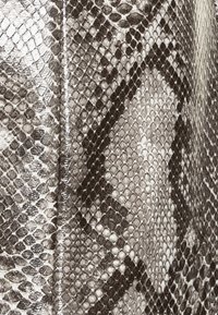 Metallische slangenhuidtextuur in tinten zilver en grijs met een ruitpatroon en glanzende afwerking, die de schubachtige details benadrukt.
