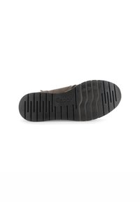 Bruine suède schoen met een rubberen zool, voorzien van horizontale groeven en "Gabor" merknaam. De zool heeft een gestructureerde afwerking voor grip.