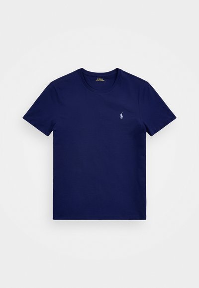 Sötétkék pamut póló, kerek nyakkal, rövid ujjakkal, és egy apró fehér polo logóval a bal mellrészen. Simább textúra.