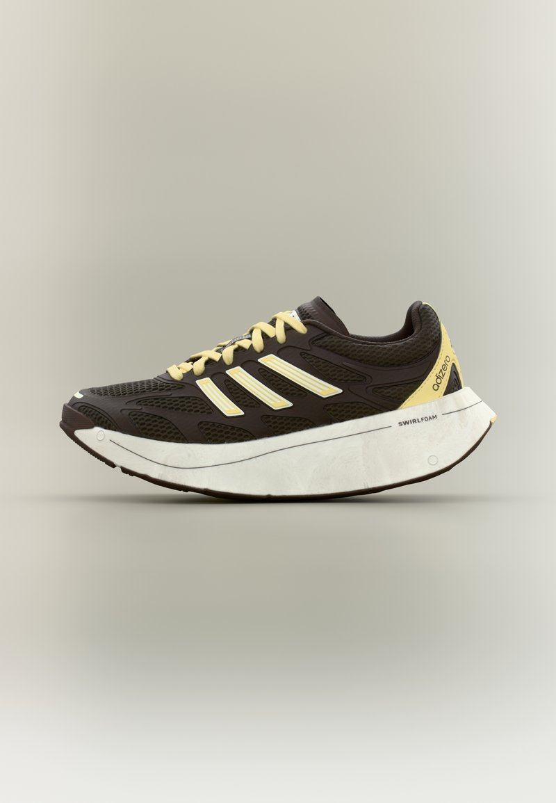 Must spordijalats võrgust pealiskattega, kollaste paelte ja detailidega, valge vahetallaga ning kaardus kujuga, mis parandab pehmendust ja toestust.