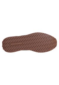 Suela de zapato de goma marrón con un patrón en zigzag, que presenta un logo grabado en el centro. Texturizada para agarre y tracción.