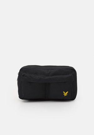 Black fabric waist bag with front zip pocket and a small yellow embroidered eagle logo on the bottom right corner.