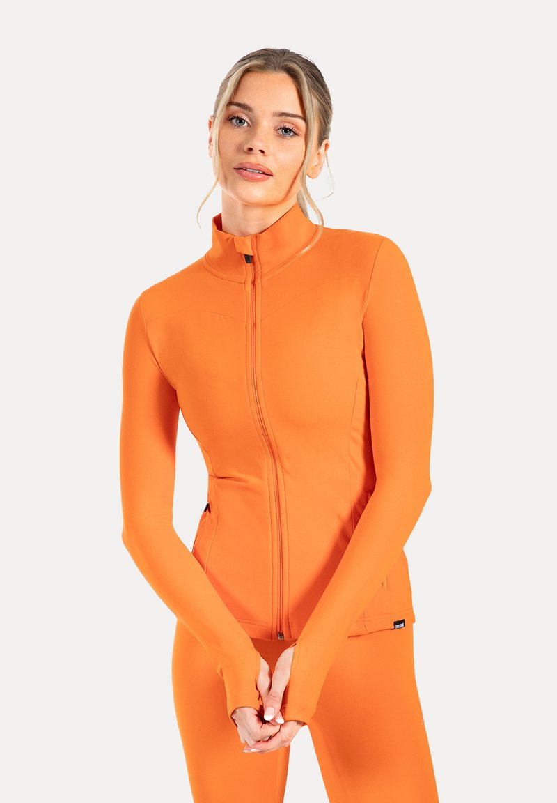 Orangene Zip-Jacke für Sport mit langen Ärmeln und Daumenlöchern, aus dehnbarem Material gefertigt. Flauschige Nähte und ein hoher Kragen.