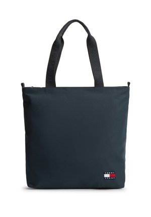 Musta suorakaiteen muotoinen kangaskassi kaksilla kahvoilla, jossa teksti "Tommy Jeans" ja pieni Tommy Jeans -logoplässi alaoikealla kulmassa.