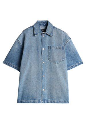 Gaiši zila džinsu krekls ar īsām piedurknēm, ar norādītu apkakli, priekšējo kabatu un snap pogām; tam ir brīvs piegriezums un nav pieminekļu.