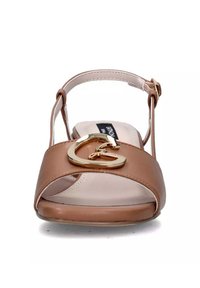 Sandal con cinturino alla caviglia marrone con una ampia fascia e un accento a forma di cuore dorato, presenta una soletta beige. Materiale liscio con un leggero tacco.