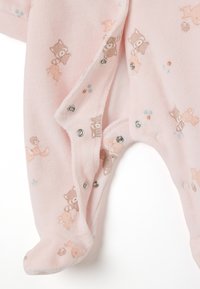 Pijama de bebé rosa hecho de tela suave, con dibujos de animales de dibujos animados y patrones florales, con cierres a presión en la parte delantera y las piernas.