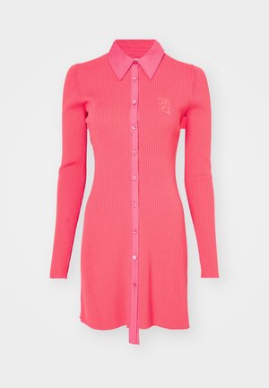 Ribotos, ilgomis rankovėmis suknelė ryškiai rožinės spalvos su apykakle, mygtukų priekyje ir maža širdelės emblema krūtinėje.