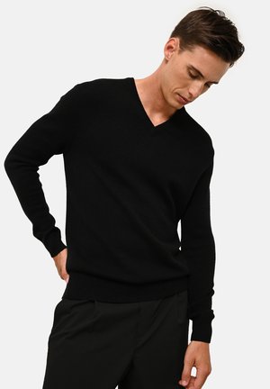 Czarny sweter z dekoltem w serek, wykonany z miękkiego materiału dzianinowego, z długimi rękawami oraz ribbowanymi mankietami i dołem. Prosty, dopasowany krój bez wzorów.