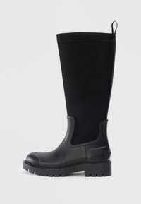 Botte noire imperméable montant jusqu'au genou avec une partie inférieure en caoutchouc lisse, une tige en néoprène, une semelle épaisse et une sangle à l'arrière.
