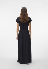 Svart maxi-klänning med korta ärmar, insvängd midja och en flödande kjol. Slät textur, enkel design och en ankel-lång silhuett.