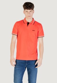 Polo shirt rosso brillante con maniche corte, colletto nero e dettagli a strisce sulle maniche. Presenta un piccolo logo nero "BOSS" sul petto.