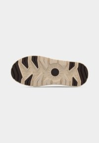 Shoe outsole in beige rubber with black accents. Features deep treads and a circular pattern at the center for traction and stability.