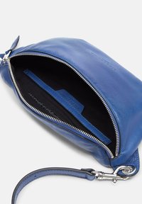Blaues Lederetui mit Reißverschluss und silbernen Beschlägen, ausgestattet mit einem schwarzen Innenfutter und einer kleinen Tasche für Karten oder wichtige Dinge.