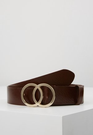 Brown leather belt with double gold circular buckle resting on a white surface against a neutral gray background.