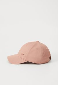 Pink cotton baseball cap with a curved brim, six ventilation holes, and a small embroidered logo on the front. Adjustable strap at the back.