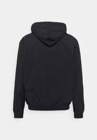 Schwarze Kapuzenjacke mit langen Ärmeln, elastischen Bündchen und elastischem Taillenbund, von hinten auf einem weißen Hintergrund fotografiert.