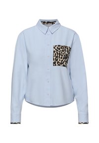 Chemise bleu clair à manches longues avec poche à imprimé léopard, détails à imprimé léopard à l'intérieur du col et des poignets.