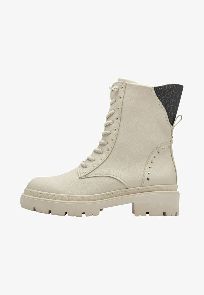 Botte en cuir beige à lacets avec un talon texturé bleu, des clous décoratifs sur le côté et un design de semelle épaisse pour une traction accrue.