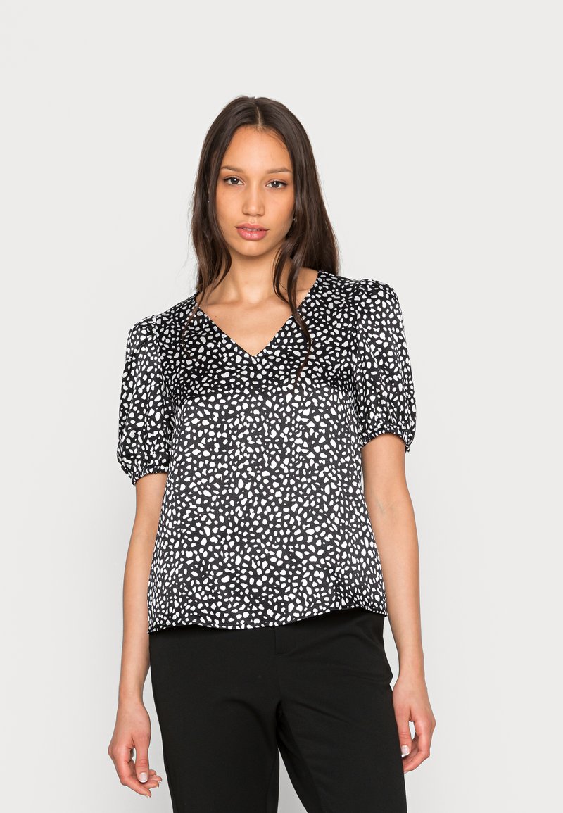 Blusa preta de manga curta com gola em V, apresentando um padrão abstrato branco. Feita de um tecido leve com um corte descontraído.