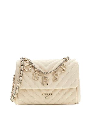 Sac à épaule matelassé beige avec bandoulière chaîne dorée et lettres suspendues formant "GUESS" au-dessus du logo de la marque sur le rabat avant.