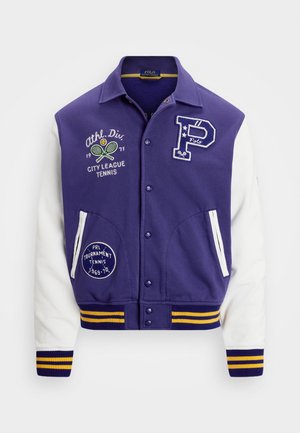 Veste universitaire violet et blanche avec boutons-pression à l'avant, écussons sur le thème du tennis et poignets et ourlet côtelés à rayures jaunes.