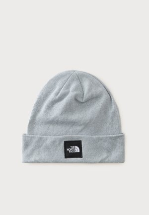 Bonnet en maille gris clair avec un revers, comportant un patch carré noir avec le logo "The North Face" en blanc.