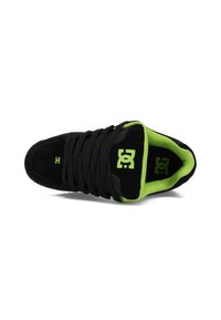 Zapatilla negra de ante con un collar y forro interior acolchado en verde. Presenta cordones negros prominentes y un logotipo verde en la lengüeta.