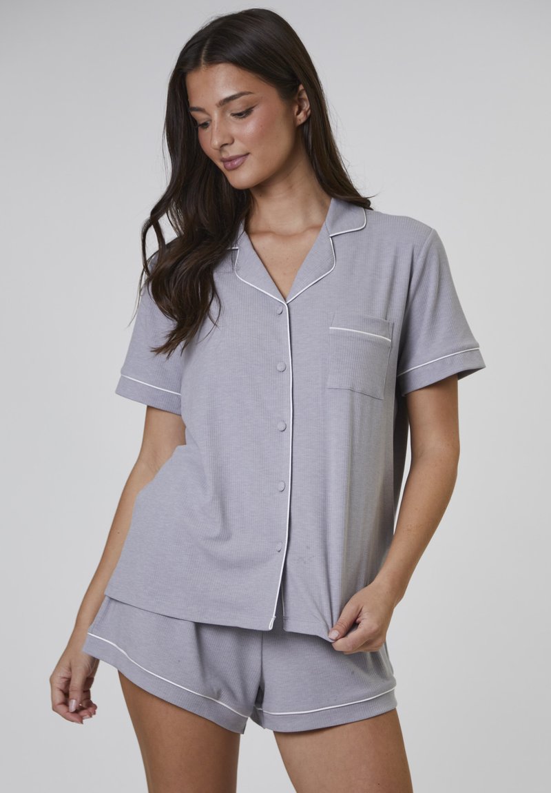 Grauene Baumwoll-Pyjama-Set mit kurzen Ärmeln und einer Tasche. Mit weißem Piping entlang des Kragens, der Knöpfe und dem Saum der Shorts.