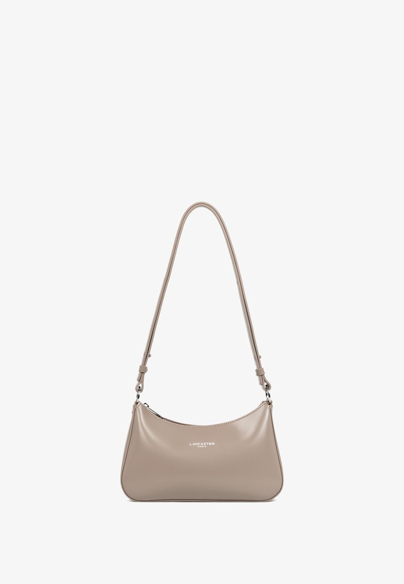 Sac à main en cuir beige en forme de demi-lune, avec une bandoulière réglable et un détail de logo argenté. Texture lisse et design minimaliste.