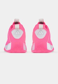 Scarpe da ginnastica rosa brillante con tomaia testurizzata, accenti bianchi e linguette sul tallone. Presentano una suola in gomma con motivo per una migliore trazione.