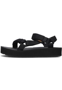 Sandalias negras con un diseño de tiras entrelazadas, hechas de material duradero, con una plantillas texturizadas y suela gruesa y plana.