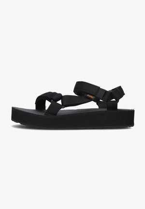 Sandalias negras con un diseño de tiras entrelazadas, hechas de material duradero, con una plantillas texturizadas y suela gruesa y plana.