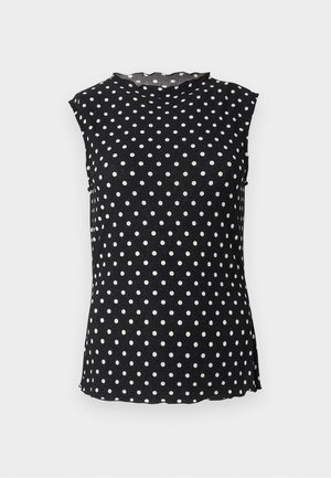 Blouse noire sans manches à pois blancs, col rond haut et bords légèrement ondulés au col et à l'ourlet.