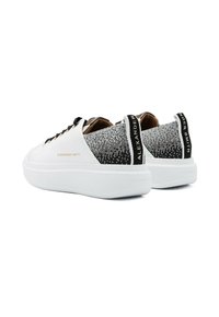 Sneaker bianche con tomaia in rete texturizzata nera e argento, linguette nere sul tallone e suole bianche in gomma spessa. Marchio sui lati.
