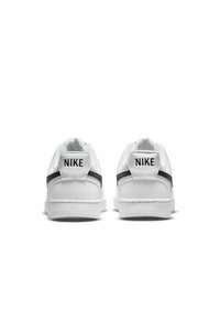 Baskets Nike blanches avec une tige en cuir texturé, une rayure noire et un col rembourré ; présente le logo Nike au dos.