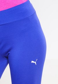Puma blå leggings med en mjuk textur och elastiskt tyg. Har en vit logotyp på vänster höft och en hög, elastisk midjeband.
